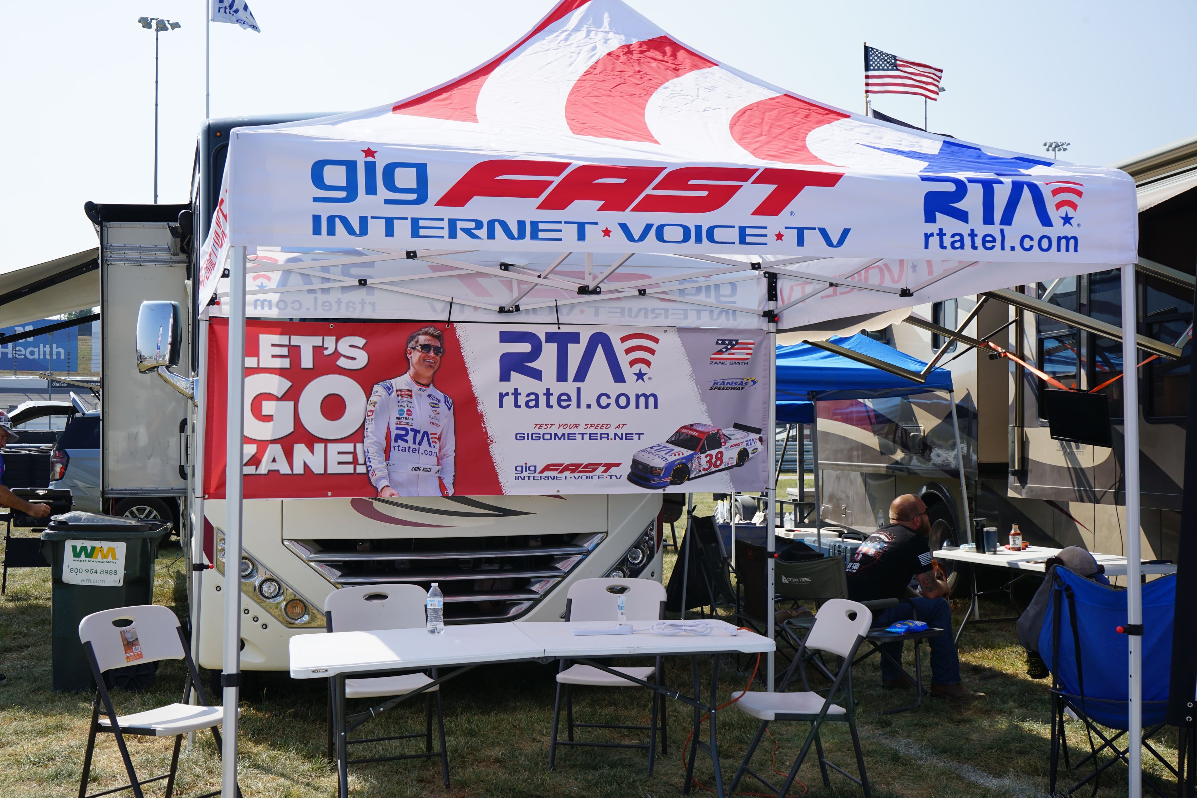 Branded event tent with gigFAST Internet and RTA logos, LET'S GO ZANE banner in background